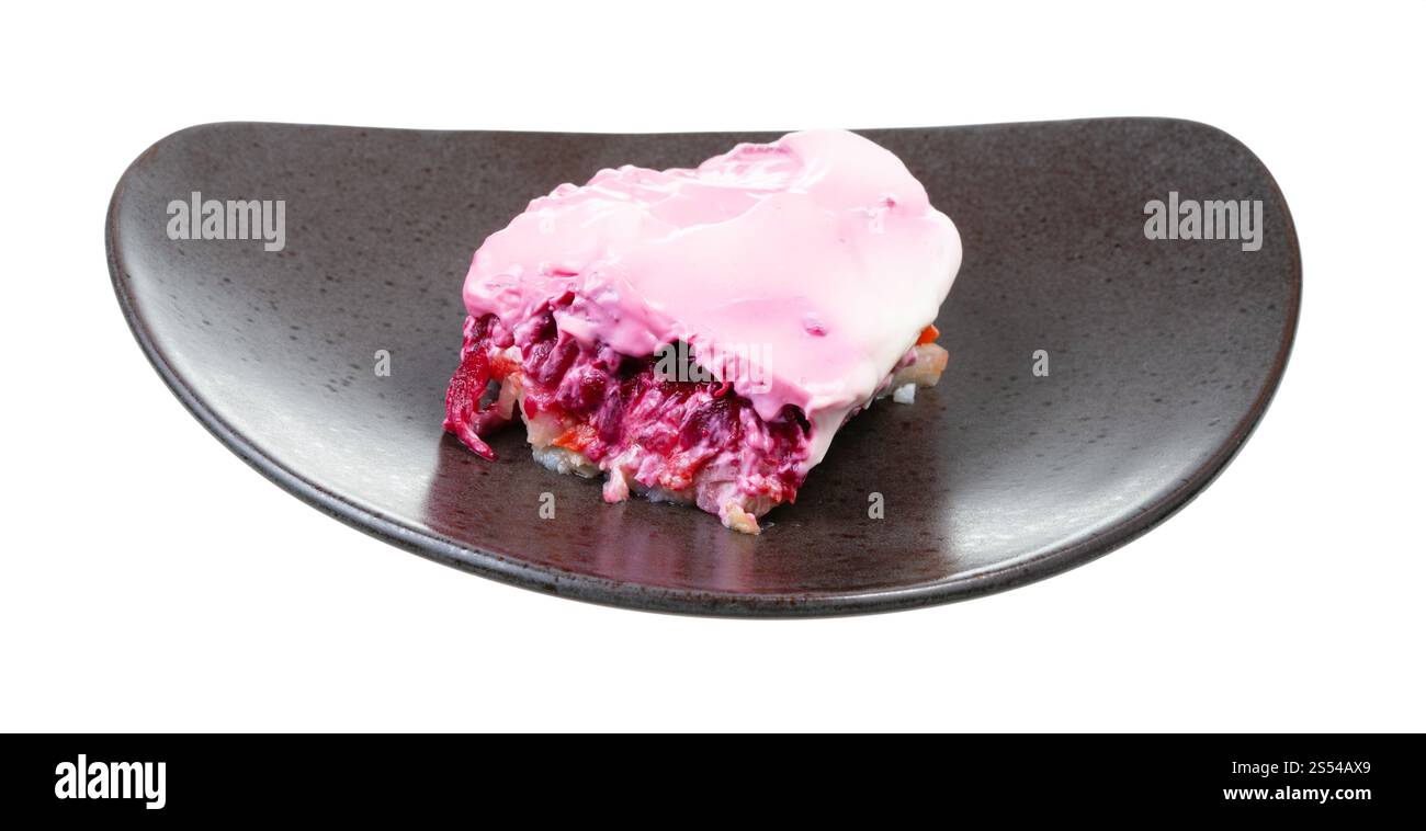 Insalata russa di aringhe su piatto nero isolato su sfondo bianco. Insalata russa di aringhe su piatto nero Foto Stock