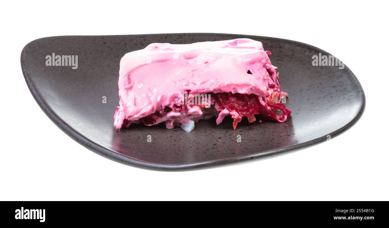 Porzione di insalata russa di aringhe su piatto nero isolato su sfondo bianco. Porzione di insalata russa di aringhe sul piatto Foto Stock