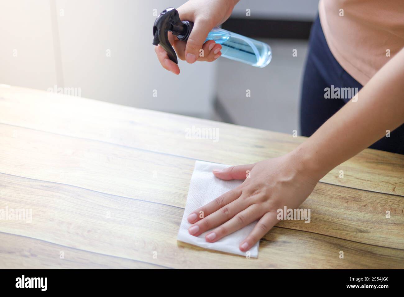 Donna spruzzando alcool disinfettante antibatterico spray per prevenire Coronavirus o Covid-19 Foto Stock