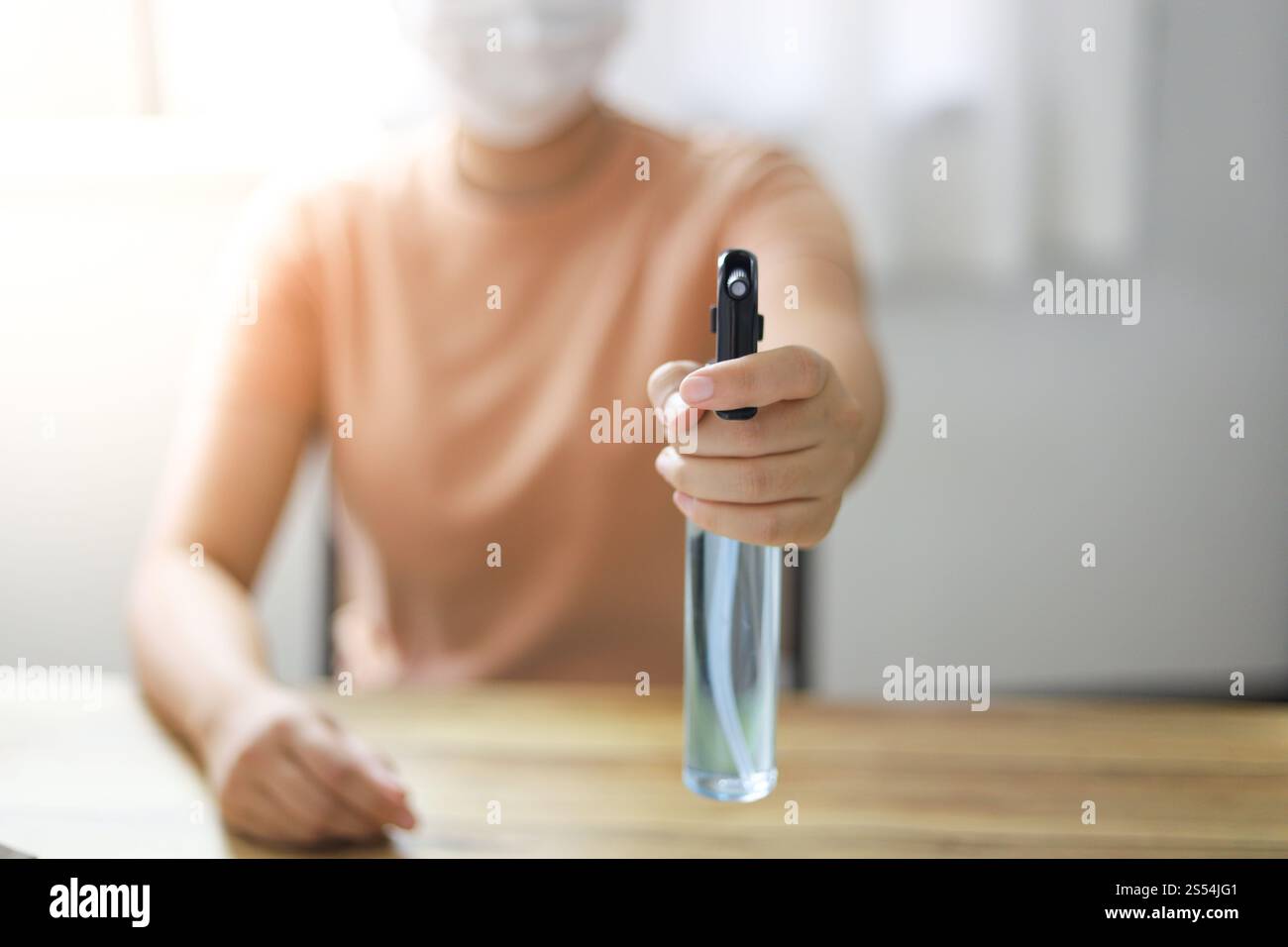 Donna spruzzando alcool disinfettante antibatterico spray per prevenire Coronavirus o Covid-19 Foto Stock