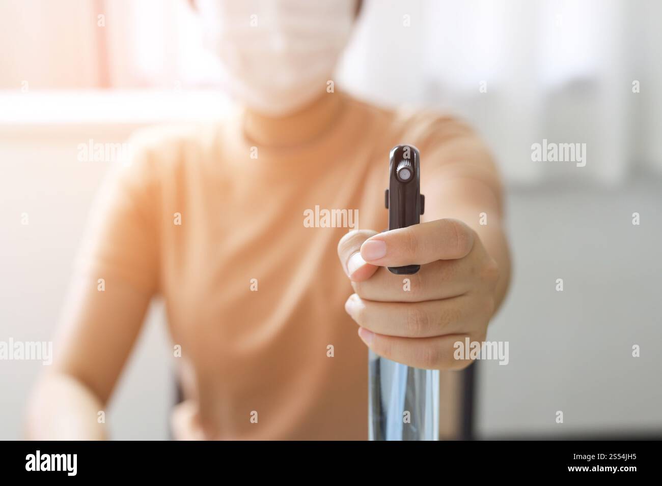 Donna spruzzando alcool disinfettante antibatterico spray per prevenire Coronavirus o Covid-19 Foto Stock