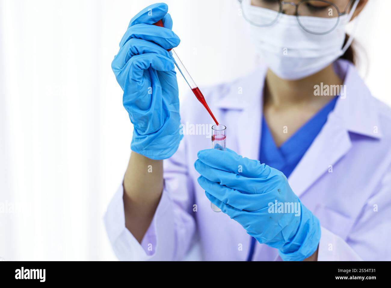 Scienziato in possesso di una provetta per il campione di sangue infetto da Coronavirus covid-19. Analisi del DNA del sangue in laboratorio con provette per il prelievo di campioni di sangue e. Foto Stock