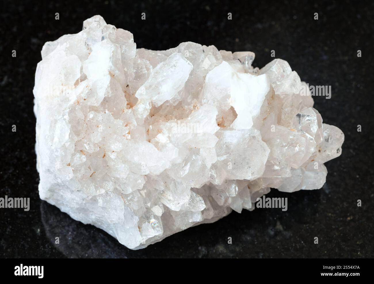 primo piano del campione di minerale naturale proveniente dalla collezione geologica - matrice non lucidata di cristalli di roccia incolore (cristallo di roccia) su granito nero Foto Stock