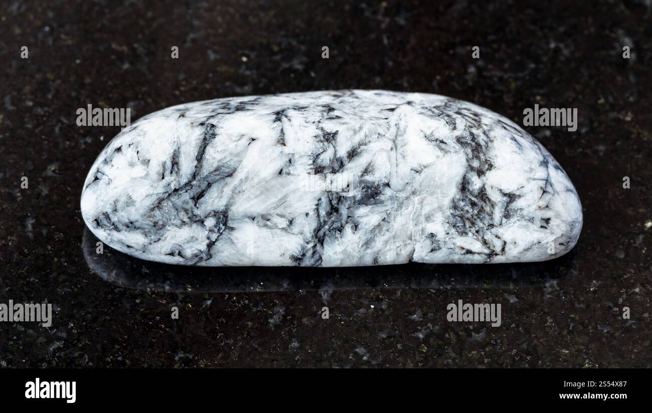 primo piano del campione di minerale naturale proveniente dalla raccolta geologica - roccia di Magnesite tumulata su fondo di granito nero proveniente dal deposito di Satkinskoe, Foto Stock