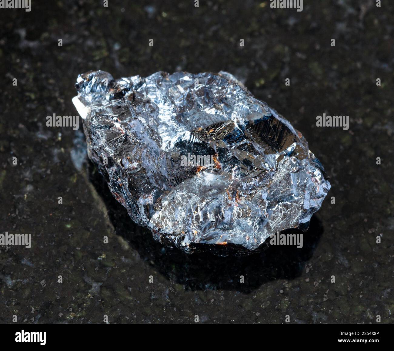 primo piano di un campione di minerale naturale proveniente dalla collezione geologica - roccia di Sfalerite non lucidata (zink blende) su fondo di granito nero da Foto Stock