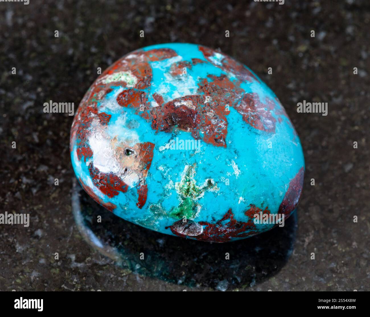 primo piano di un campione di minerale naturale proveniente dalla raccolta geologica - Chrysocolla tumulata con roccia di Cuprite su fondo di granito nero. rovesciato Foto Stock