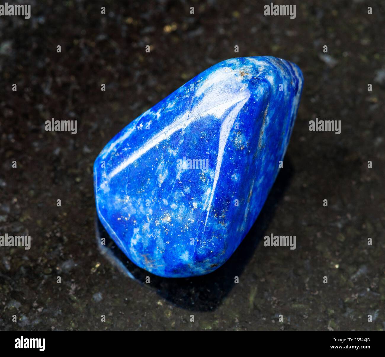 primo piano di un campione di minerale naturale proveniente dalla collezione geologica - roccia lucida di Lapis Lazuli (Lazurite) su sfondo di granito nero proveniente dall'Afghanistan. Foto Stock