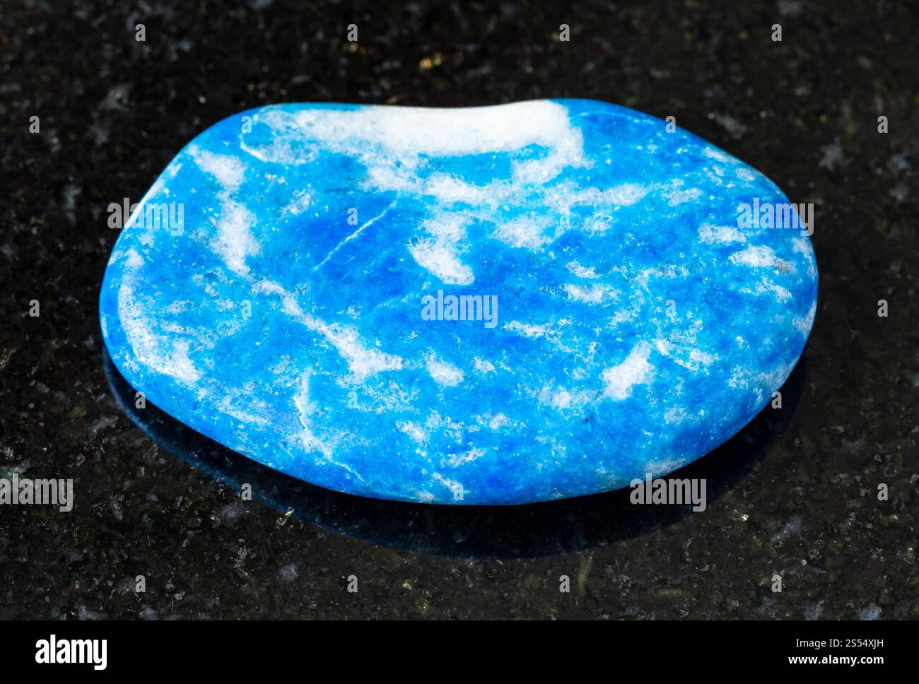 primo piano di un campione di minerale naturale proveniente dalla collezione geologica - roccia lazzurita lucidata (Lapis Lazuli) su sfondo granito nero proveniente dal Tagikistan. Foto Stock