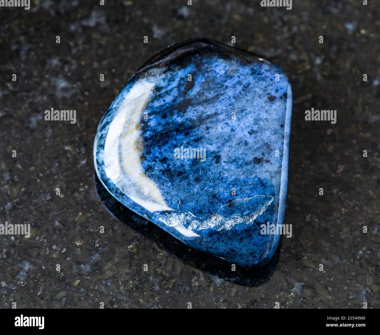 primo piano di un campione di minerale naturale proveniente dalla raccolta geologica - roccia tumulata di Dumortierite su fondo di granito nero proveniente dal Mozambico. rovesciato Foto Stock