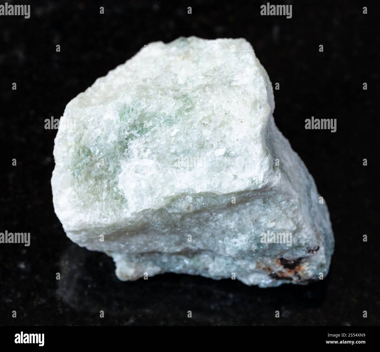 primo piano di un campione di minerale naturale proveniente dalla collezione geologica - roccia di Carbonatite non lucidata su fondo di granito nero. Carbonatite non lucida Foto Stock