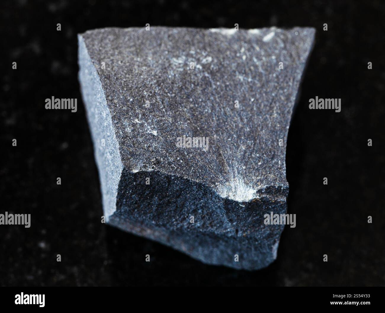 primo piano di un campione di minerale naturale proveniente dalla collezione geologica - roccia Hyalobasalt non lucidata su fondo di granito nero. Hyalobasalt non lucidato Foto Stock