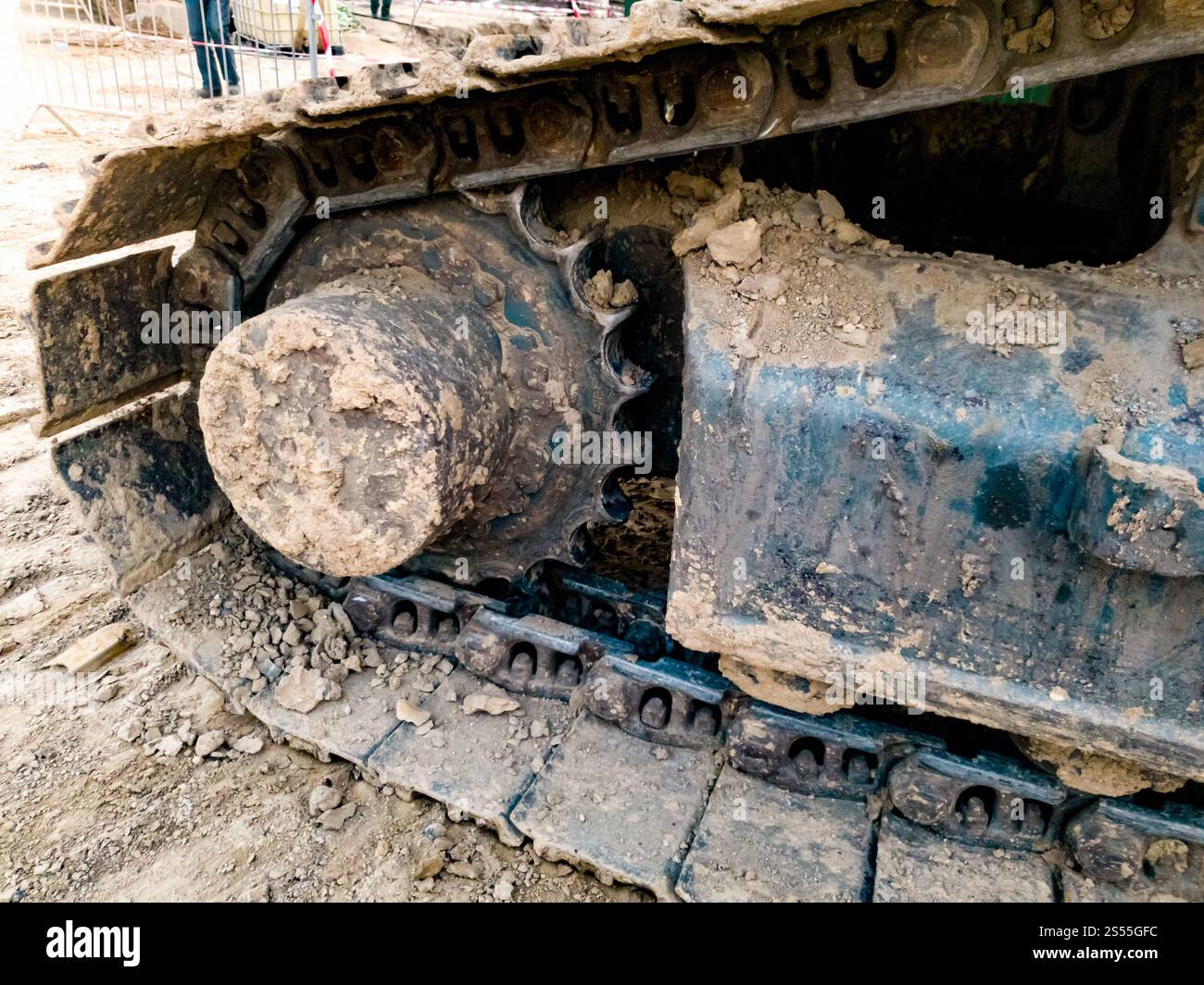 Foto ravvicinata dei binari dell'escavatore ricoperti di sporcizia nel cantiere. Immagine ravvicinata dei cingoli dell'escavatore ricoperti di sporcizia nel cantiere Foto Stock