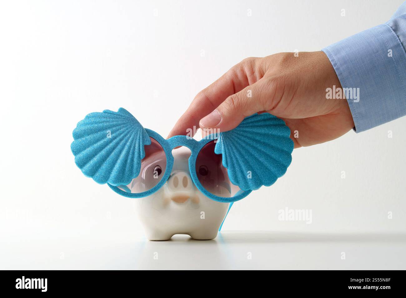 Concetto di assicurazione di viaggio. Agente assicurativo di affari mano in gesto di protezione del salvadanaio con occhiali da sole con conchiglia su sfondo bianco Foto Stock