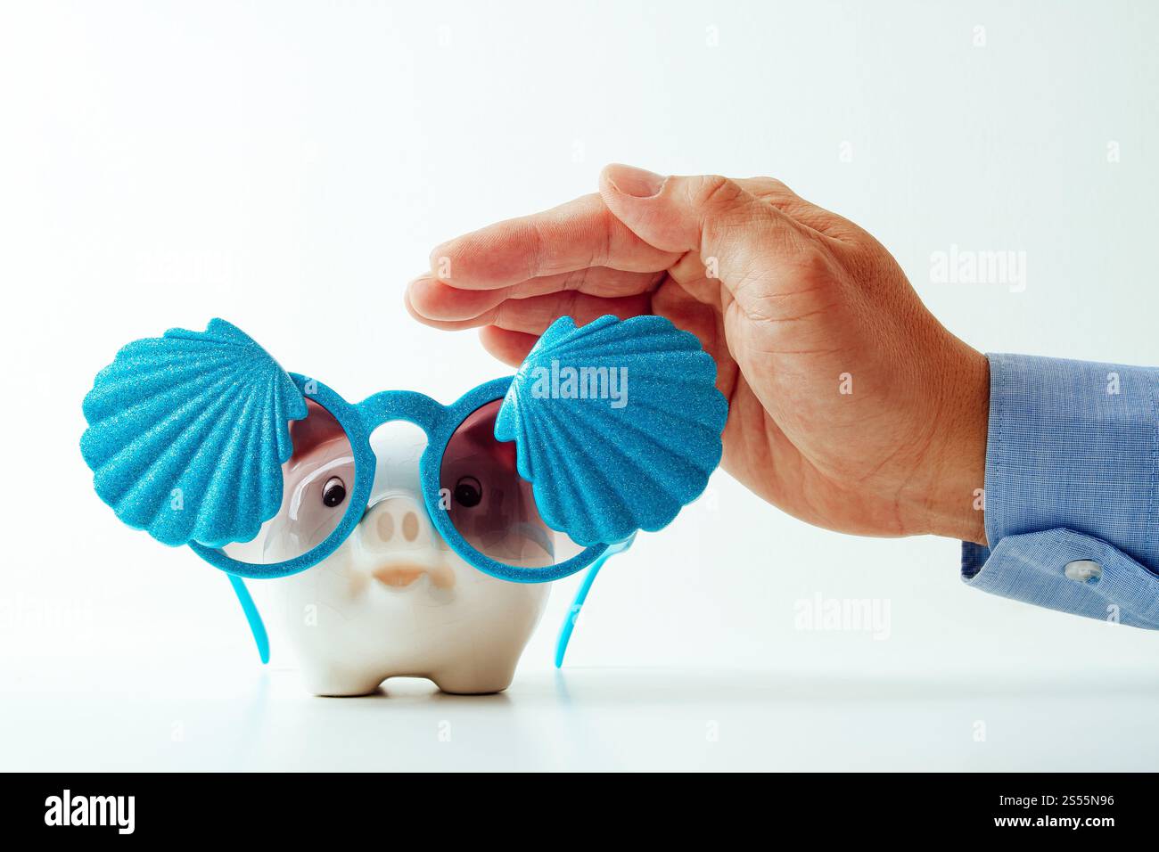 Concetto di assicurazione di viaggio. Agente assicurativo di affari mano in gesto di protezione del salvadanaio con occhiali da sole con conchiglia su sfondo bianco Foto Stock