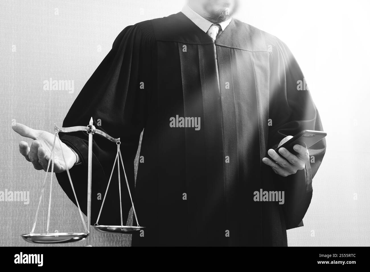 La giustizia e la nozione di diritto.Giudice maschi nelle aule di un tribunale con la bilancia e utilizzo di smart phone Foto Stock