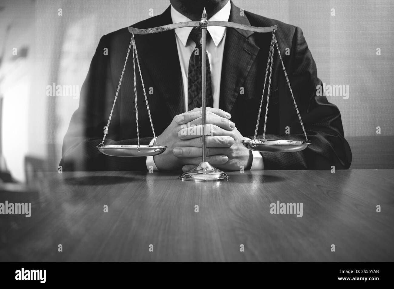 La giustizia e la nozione di diritto.avvocato maschio in ufficio con scala di ottone sul tavolo di legno,in bianco e nero Foto Stock