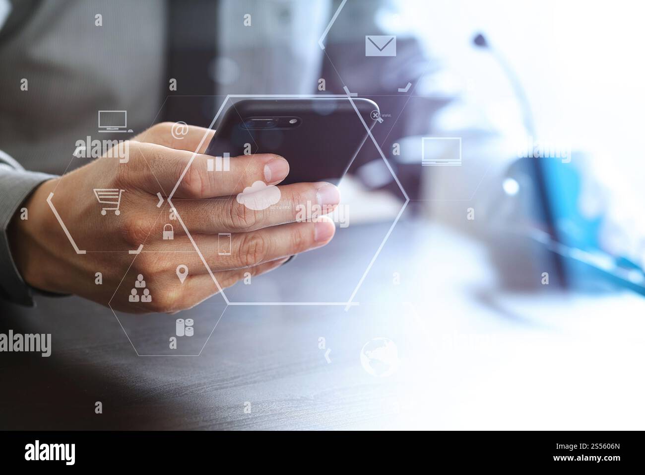 Imprenditore tramite VOIP auricolare con il telefono cellulare e il concetto di comunicazione centro di chiamata sulla scrivania in legno con la realtà virtuale diagramma icona Foto Stock