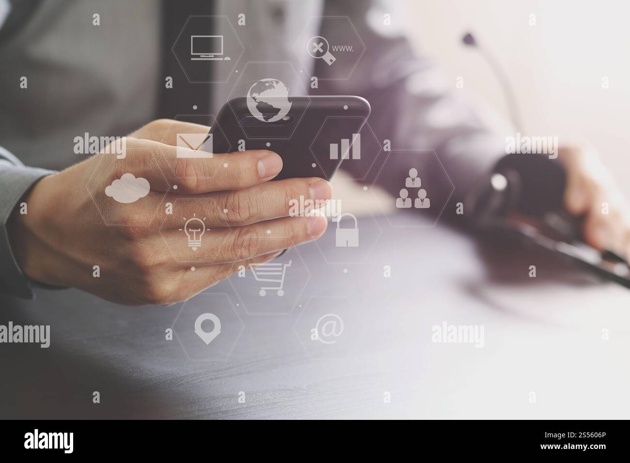 Imprenditore tramite VOIP auricolare con il telefono cellulare e il concetto di comunicazione centro di chiamata sulla scrivania in legno con la realtà virtuale diagramma icona Foto Stock