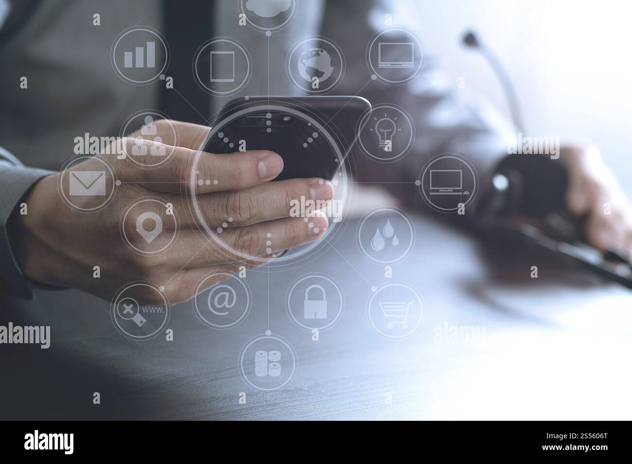 Imprenditore tramite VOIP auricolare con il telefono cellulare e il concetto di comunicazione centro di chiamata sulla scrivania in legno con la realtà virtuale diagramma icona Foto Stock