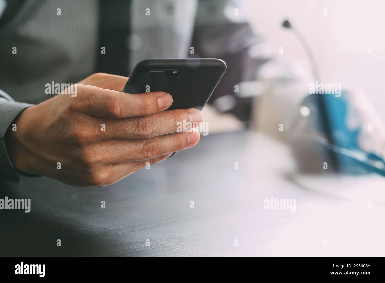 Imprenditore tramite VOIP auricolare con il telefono cellulare e il concetto di comunicazione centro di chiamata sulla scrivania in legno Foto Stock