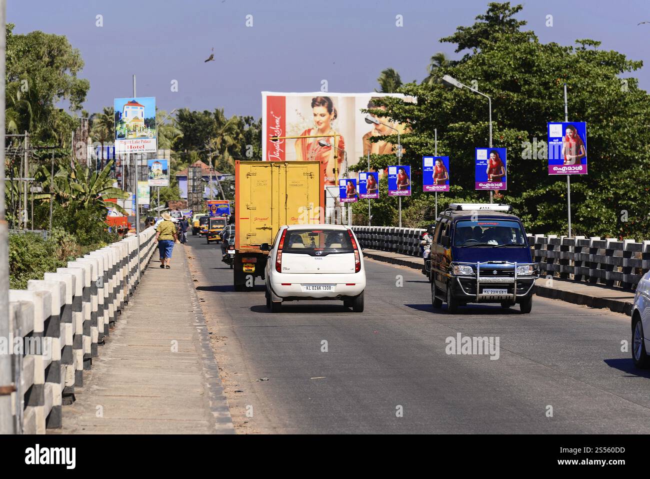 Fort Cochin, Cochin, Kerala, India meridionale, India, Asia, Una strada trafficata con auto e poster colorati lungo il ponte, Kovalam, Malabar Coast, Malabar Foto Stock