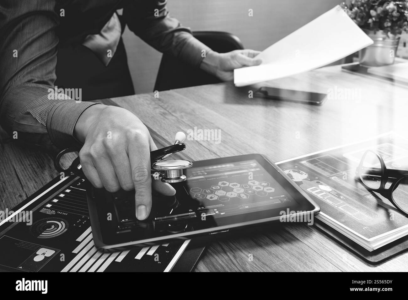 Medico che lavorano con tavoletta digitale computer con smart phone in area di lavoro medico ufficio e video conferenza come concetto,bianco nero Foto Stock