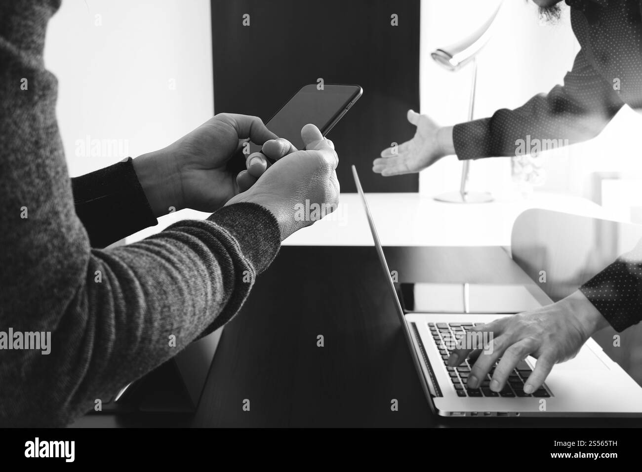 Co team di lavoro riunione concetto,imprenditore utilizzando smart phone in ufficio moderno,in bianco e nero Foto Stock