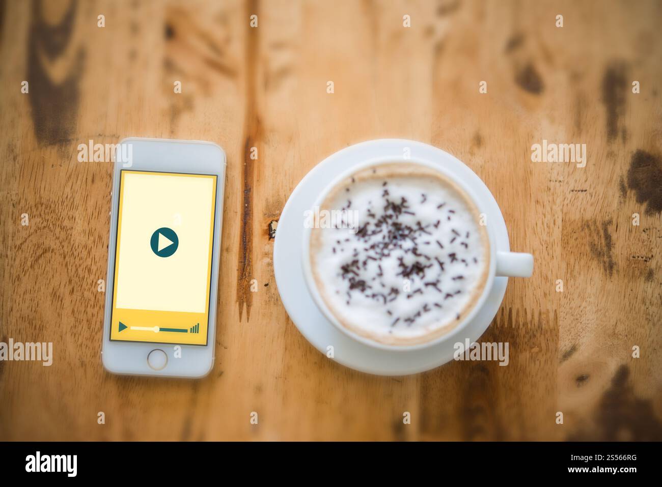 Multimedia video player sulla schermata dello smartphone con una tazza di caffè. Vacanza rilassante. Foto Stock