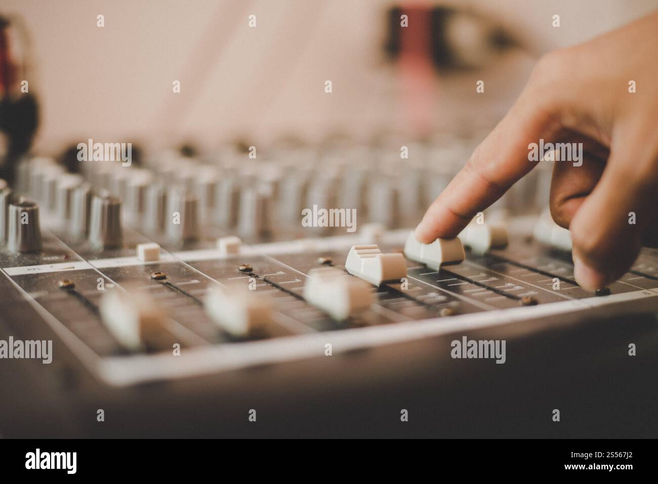 Man mano di ingegnere del suono regolazione audio console di miscelazione. Foto Stock