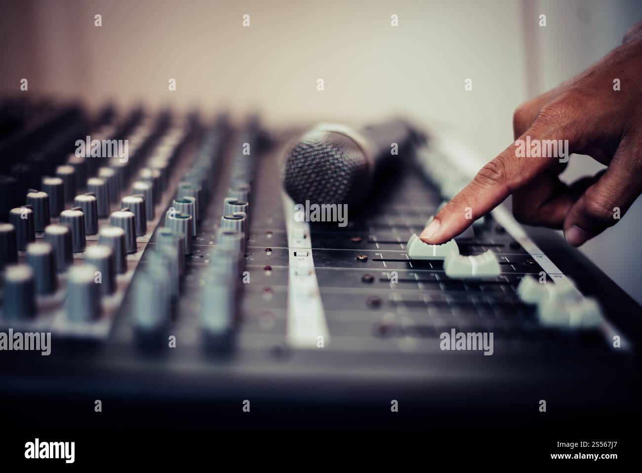Man mano di ingegnere del suono regolazione audio console di miscelazione. Foto Stock