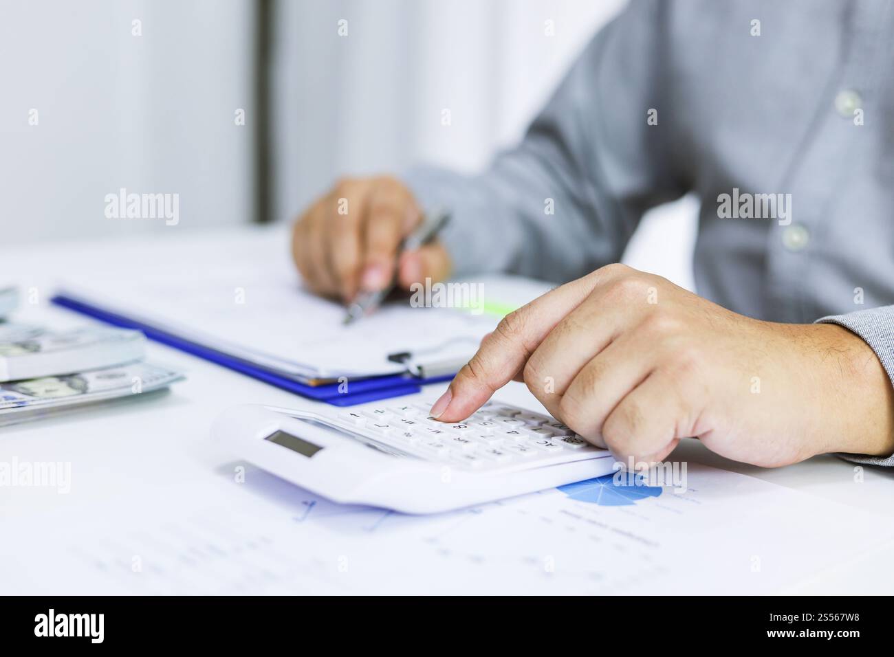 Uomo d'affari che controlla le fatture, le imposte, il saldo del conto bancario e calcola il bilancio annuale della società. Concetto di verifica contabile. Foto Stock