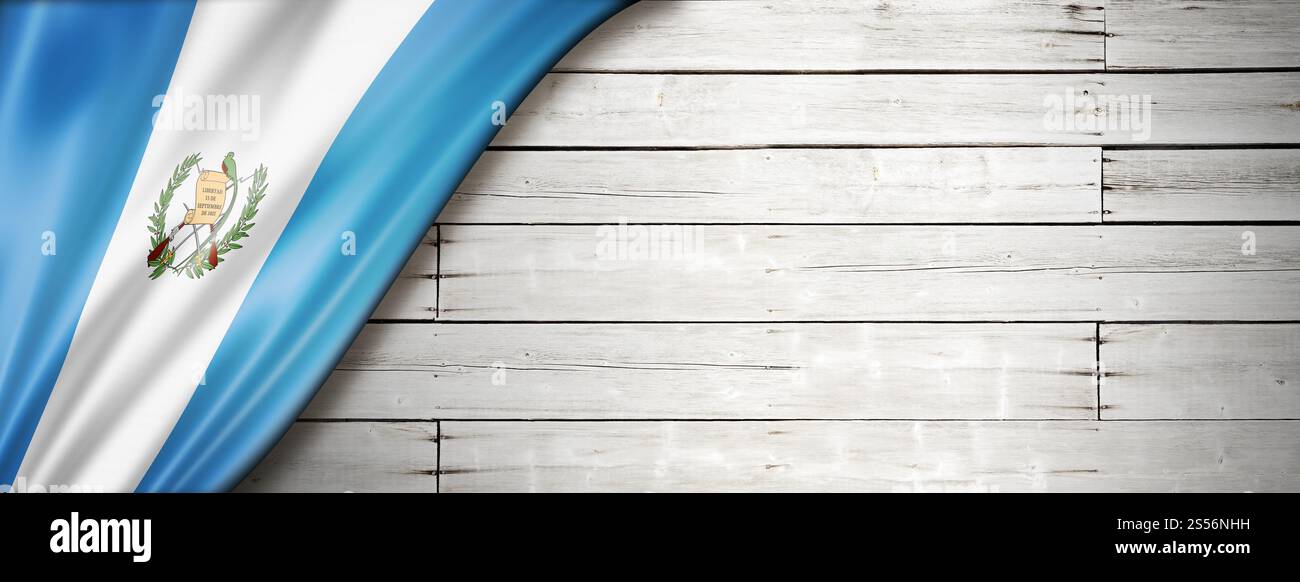 Bandiera del Guatemala sul vecchio muro bianco. Striscione panoramico orizzontale. Bandiera guatemalteca sul vecchio stendardo bianco Foto Stock