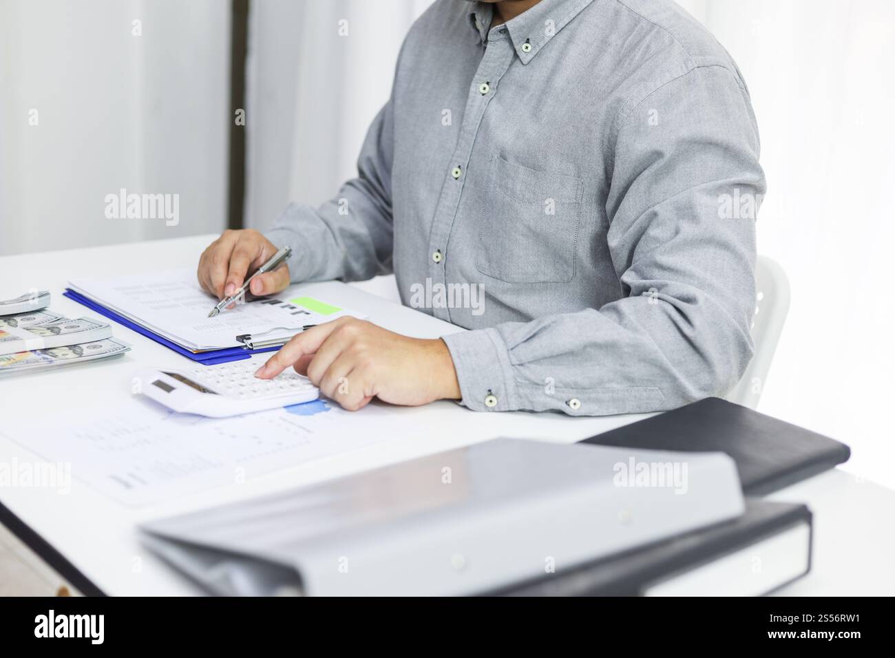 Uomo d'affari che controlla le fatture, le imposte, il saldo del conto bancario e calcola il bilancio annuale della società. Concetto di verifica contabile. Foto Stock