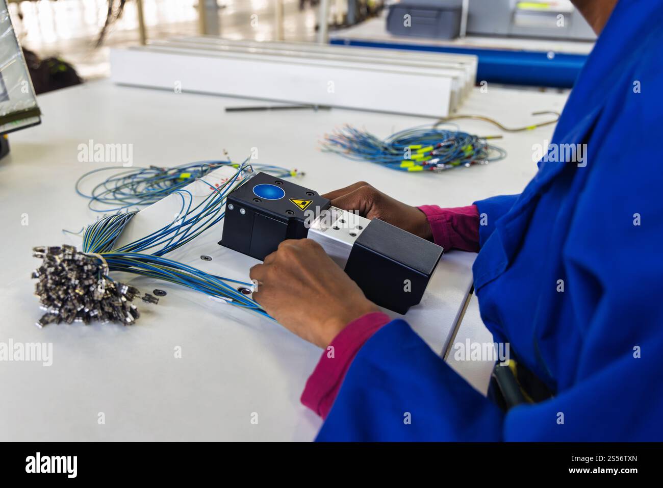 cavi del cablaggio dell'automobile, pannello di fabbrica del cablaggio dell'auto, fabbrica di cablaggi elettrici dell'automobile, mani africane dell'uomo Foto Stock