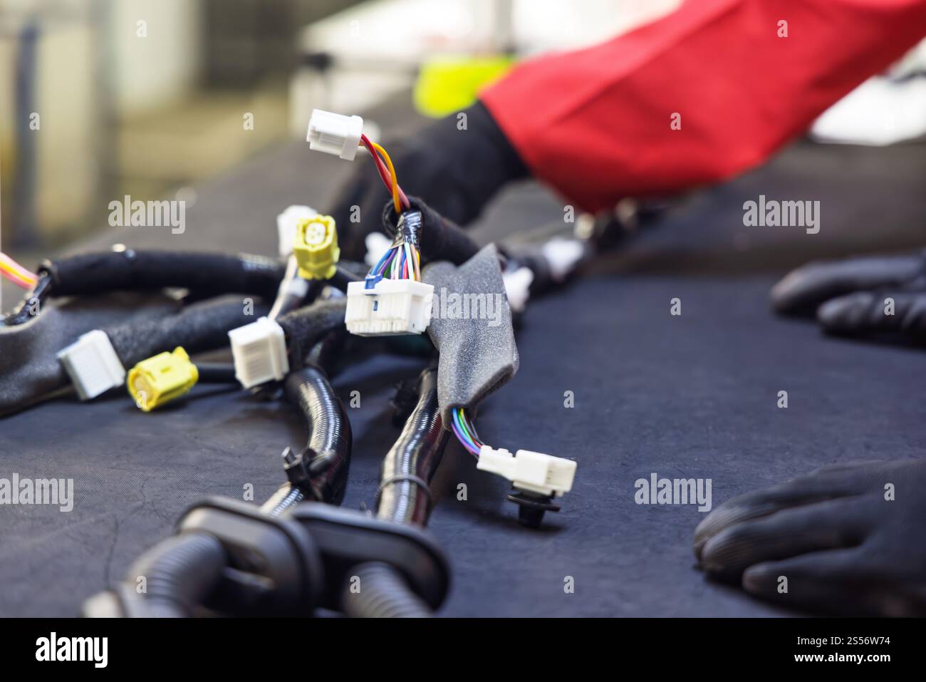 cablaggio automatico pannello di fabbrica, fabbrica di cablaggi elettrici per auto, pannello con fili tubi e connettori, lavoratore afroamericano Foto Stock