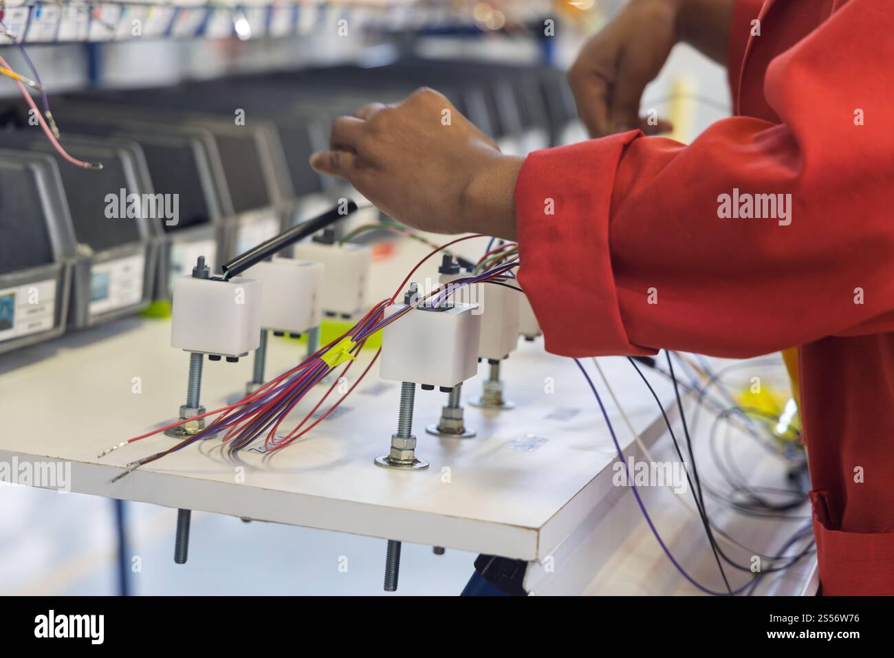cablaggio automatico pannello di fabbrica, fabbrica di cablaggi elettrici per auto, pannello con fili tubi e connettori, lavoratore afroamericano Foto Stock