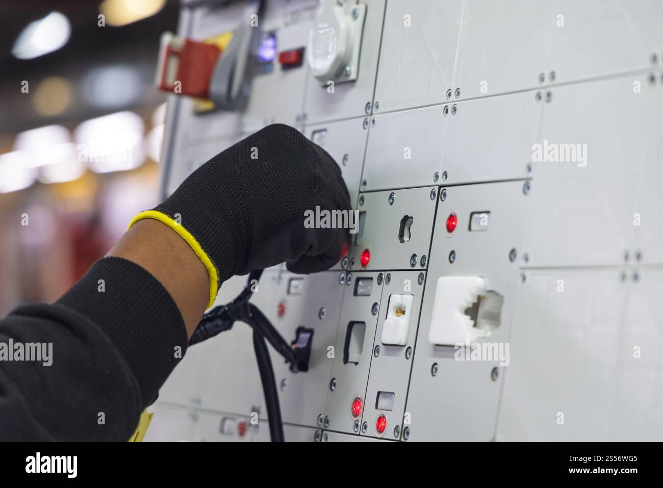 cablaggio automatico pannello di fabbrica, fabbrica di cablaggi elettrici per auto, pannello con fili tubi e connettori, lavoratore afroamericano Foto Stock