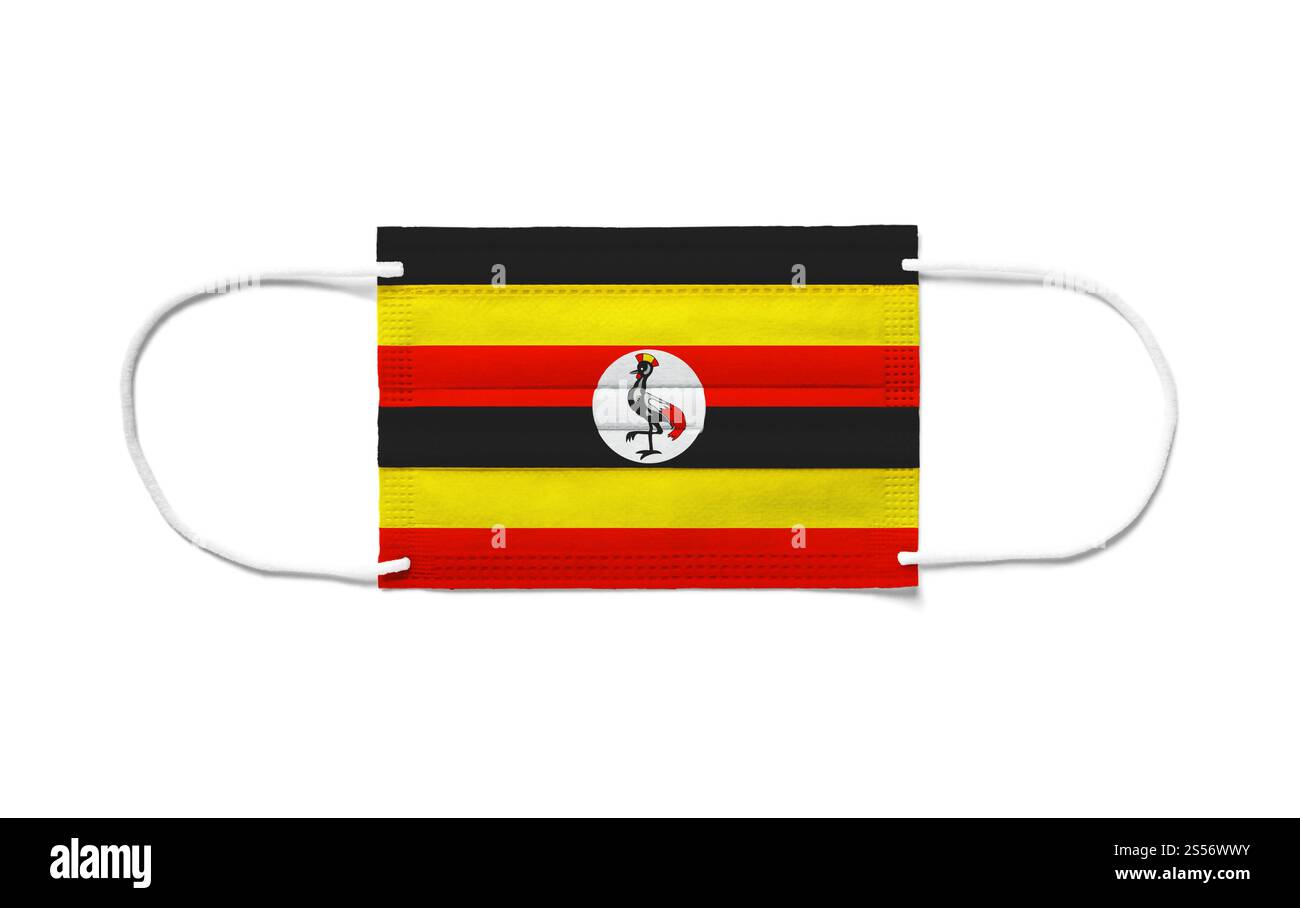 Bandiera dell'Uganda su una maschera chirurgica monouso. Sfondo bianco isolato. Bandiera dell'Uganda su una maschera chirurgica monouso. Sfondo bianco Foto Stock
