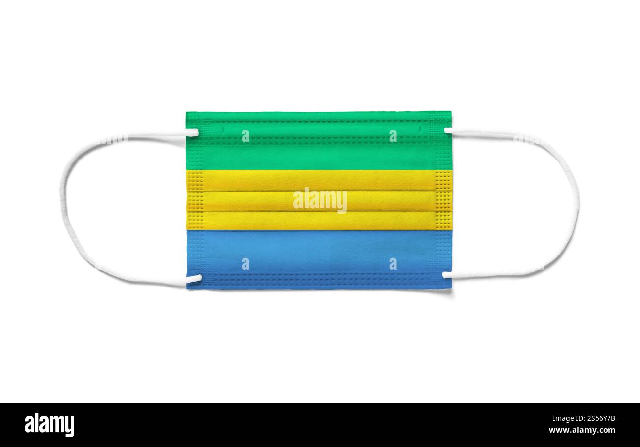 Bandiera del Gabon su una maschera chirurgica monouso. Sfondo bianco isolato. Bandiera del Gabon su una maschera chirurgica monouso. Sfondo bianco Foto Stock
