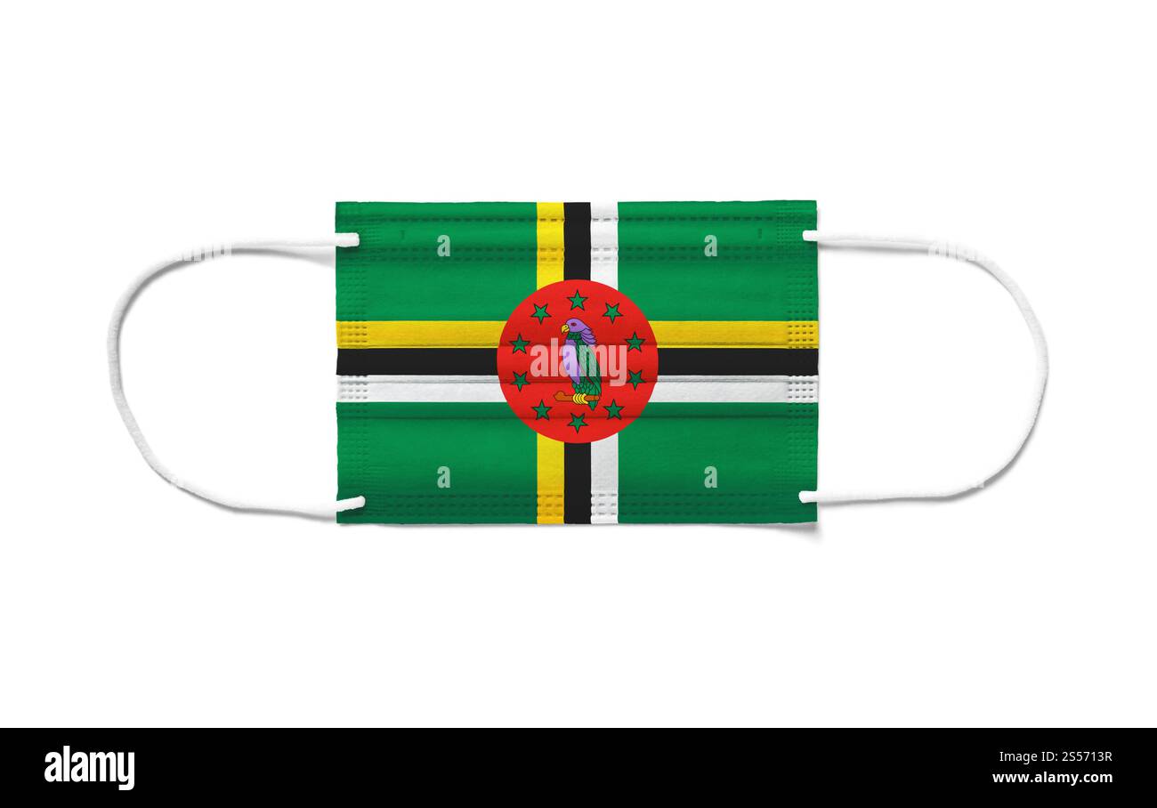 Bandiera di Dominica su una maschera chirurgica monouso. Sfondo bianco isolato. Bandiera di Dominica su una maschera chirurgica monouso. Sfondo bianco Foto Stock