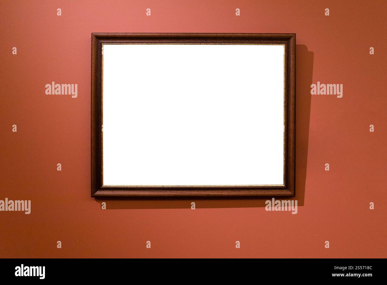 cornice in legno marrone con telo ritagliato su scuro parete rossa Foto Stock