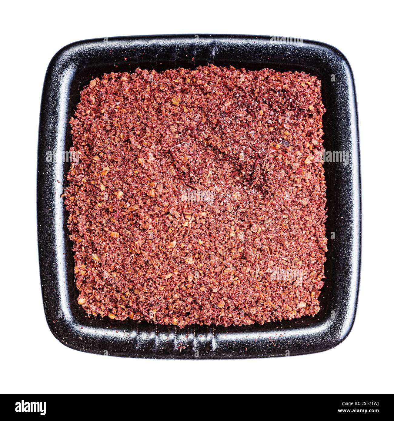vista dall'alto delle spezie sumac macinate nella ciotola nera isolata su sfondo bianco Foto Stock