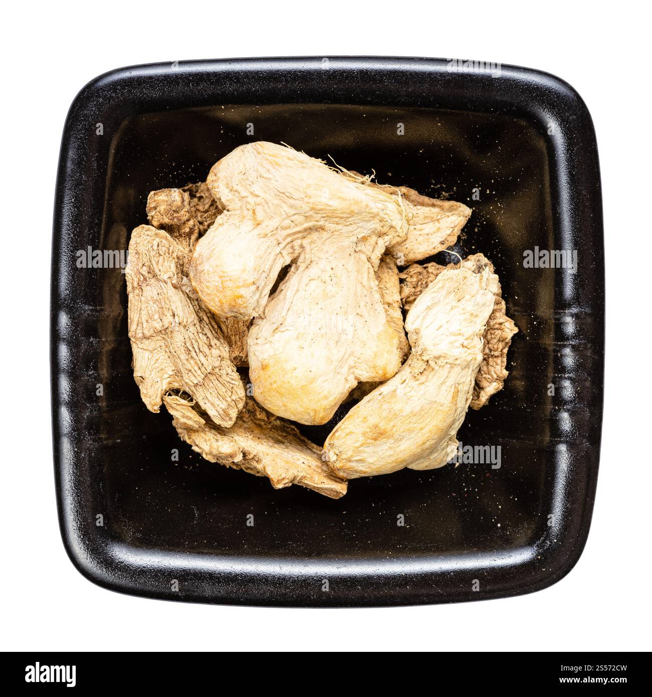 vista dall'alto di pezzi di zenzero secchi in ciotola nera isolato su sfondo bianco Foto Stock