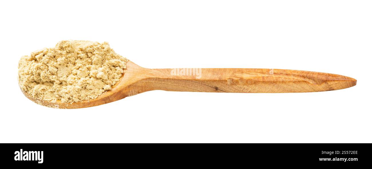 cucchiaio di legno con polvere di zenzero isolato su fondo bianco Foto Stock