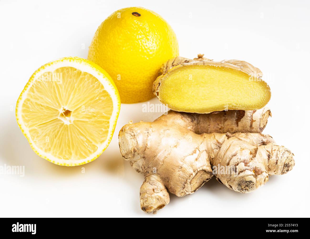 radici di zenzero intagliate e fresche naturali e limone tagliato a croce frutta su piatto grigio primo piano Foto Stock