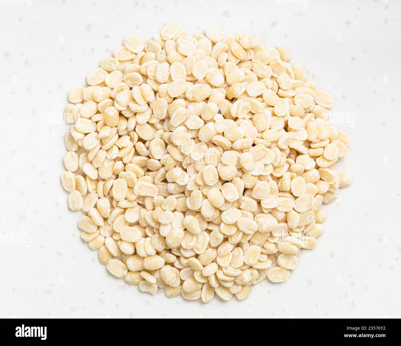 pila di urad dal grezzo (grammo nero diviso) i fagioli si avvicinano alla piastra in ceramica grigia Foto Stock