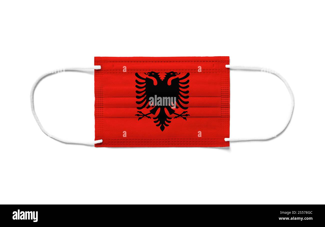Bandiera dell'Albania su una maschera chirurgica monouso. Sfondo bianco isolato. Bandiera dell'Albania su una maschera chirurgica monouso. Sfondo bianco Foto Stock