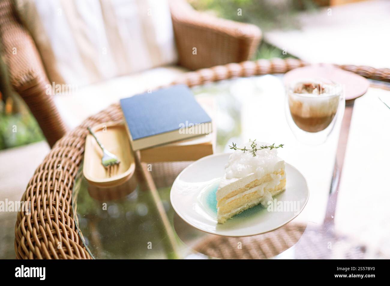 Torta al cocco e caffè in una caffetteria sullo sfondo sfocato. Dessert tradizionale a fette di deliziosa torta a strati di cocco. Foto Stock