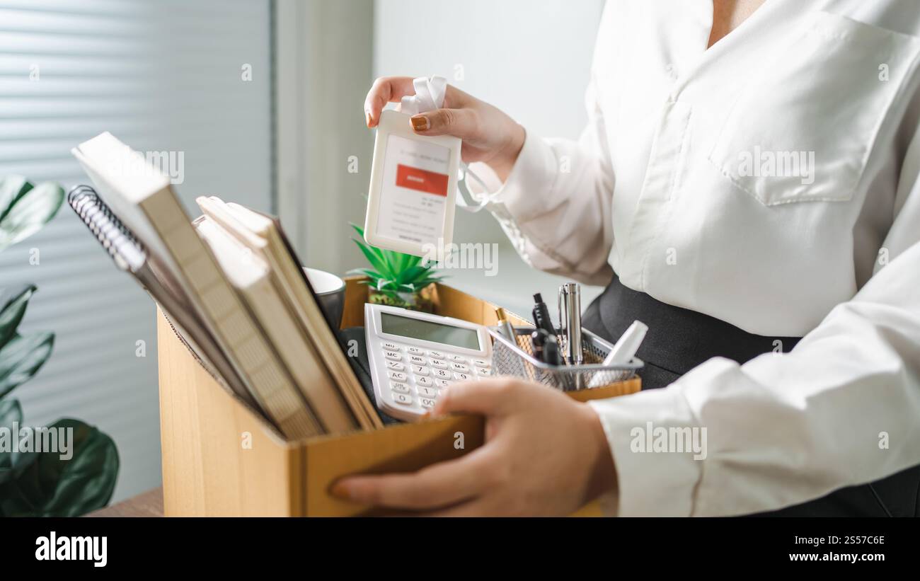Donna d'affari che invia una lettera di dimissioni e materiale da imballaggio, si dimette dalla depressione o porta con sé una scatola di cartone da lavoro alla scrivania in ufficio. Cambio di lavoro o. Foto Stock Donna d'affari che invia una lettera di dimissioni e materiale da imballaggio, si dimette dalla depressione o porta con sé una scatola di cartone da lavoro alla scrivania in ufficio. Cambio di lavoro o. Foto Stock