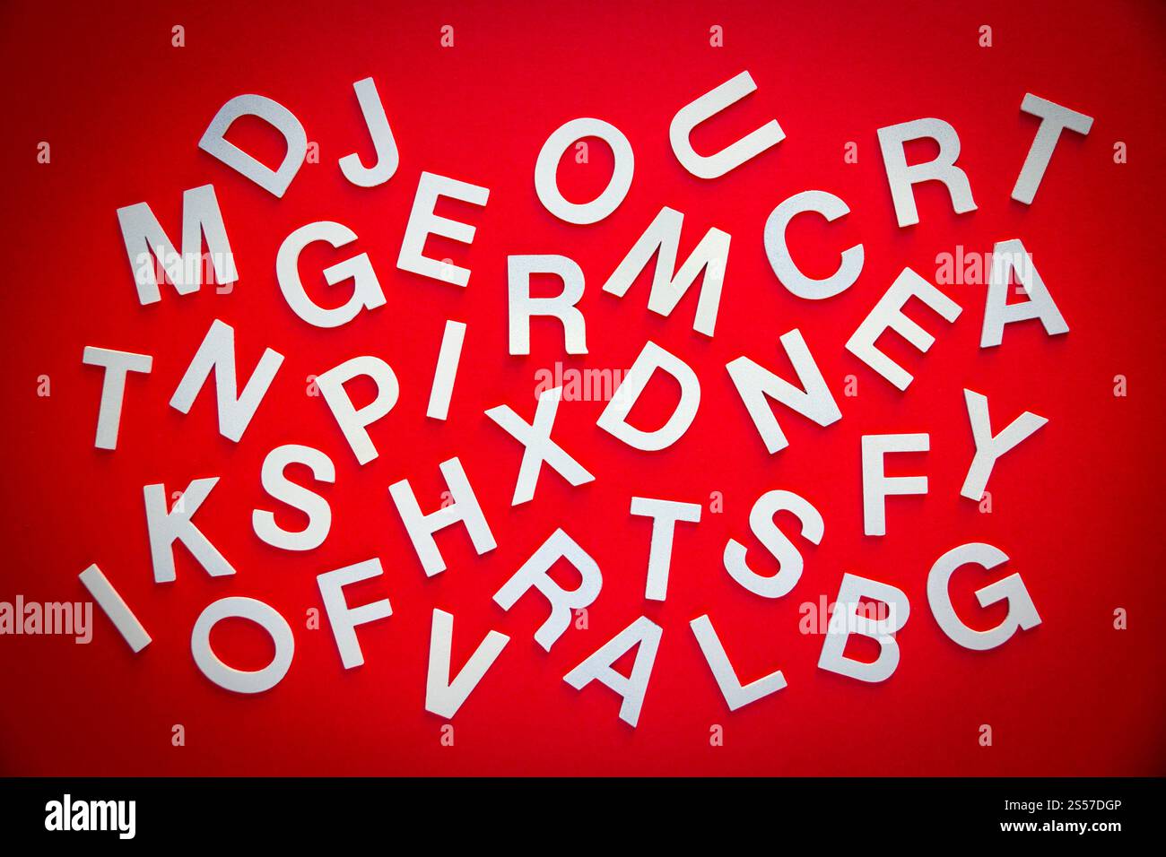 Foto vista dall'alto con lettere pila pila pila di lettere pila Concetto educativo su sfondo rosso. Foto vista dall'alto pile di lettere miste. Sfondo rosso Foto Stock